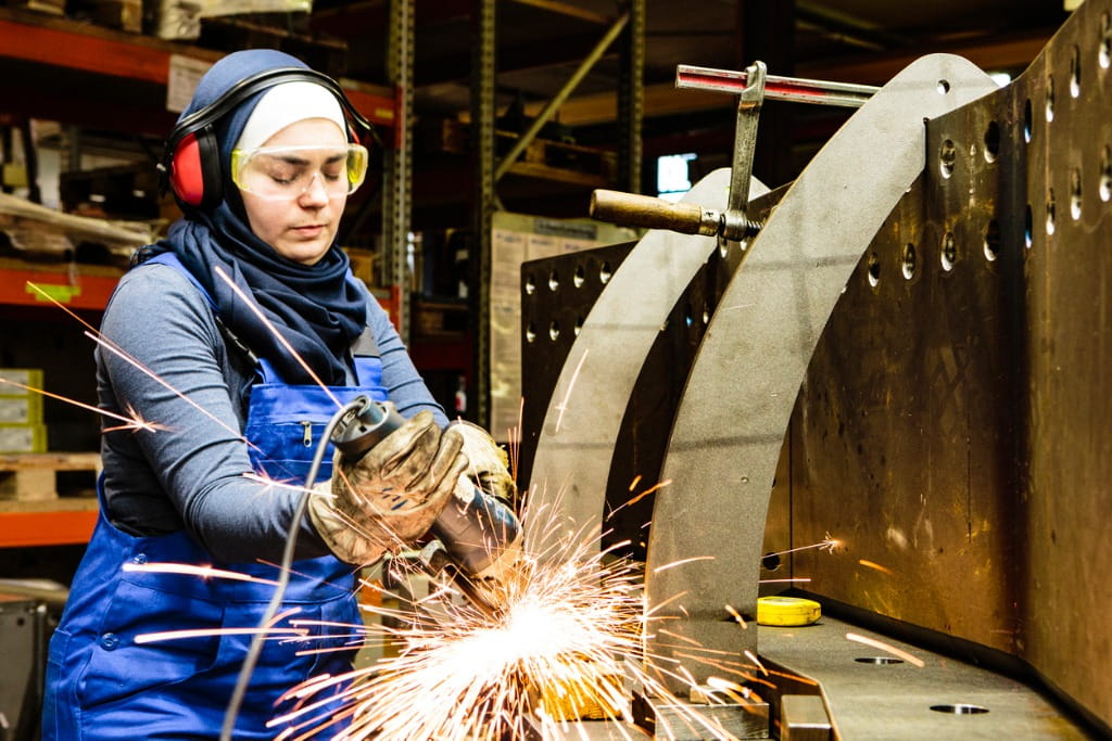 Essential Pros franchise young female grinder in workshop fight employment